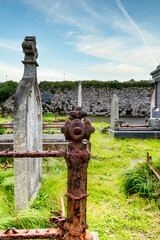 Alter Grabstein und eine rostige Einfriedung mit Dekor