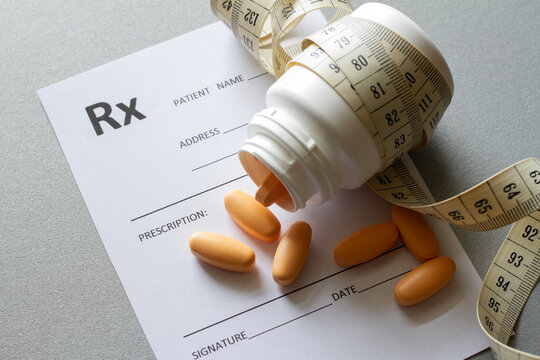 Pills, prescription and tape measure, prescription weight loss pills concept