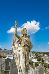 Großer alter Engel mit erhobener Hand auf einem Friedhof in St. Ives 