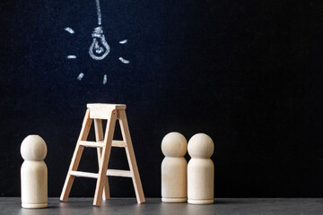 Glowing light bulb drawn with chalk on blackboard with wooden ladder and people figurines, concept of new ideas, innovations and solutions in business
