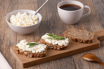 Homemade rye bread with cottage cheese in a plate and coffee. Healthy breakfast concept