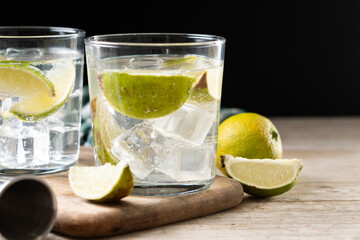 Glass of vodka tonic cocktail on wooden table. Copy space