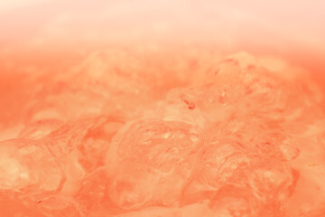 Fototapeta premium Abstract nude and peach fuzz color gradient background. Water surface. Clear water surface texture with splashes and bubbles.