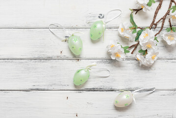 Easter background with eggs and decorative cherry branch, white wooden table. Top view, flat lay. - 757107172