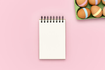 Blank notebook on pink background with egg carton