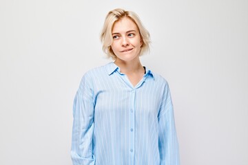 Portrait of smiling woman in blue shirt on white background, expressing positivity and confidence.