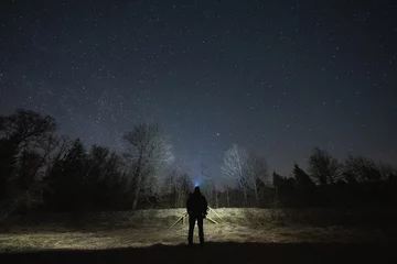 Crédence de cuisine en verre imprimé Gris 2 Night scene, landscape astrophoto, Estonian nature. A man with a headlamp in a field.