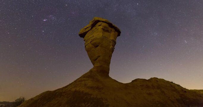 Night sky full of stars in Iran natural landscape of dark sky wonders and alone single desert rock cliff made by wind erosion at night camping adventure visit attraction in Iran astronomy photography