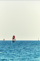Windsurfers enjoying on blue sea waters.