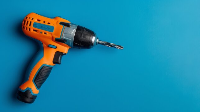 A drill rests on a smooth blue surface, waiting to be picked up and put to use