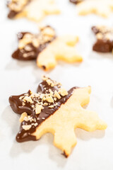 Fototapeta na wymiar Making Cutout Sugar Cookies, Chocolate-Dipped, Hazelnut-Sprinkled