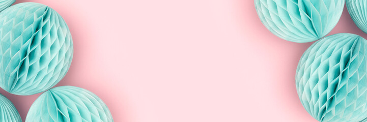 Banner with frame made of blue tissue paper balls on a pink background. Creative festive...