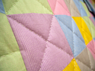 Fragment of a patchwork quilt made of multi-colored fabric rectangles