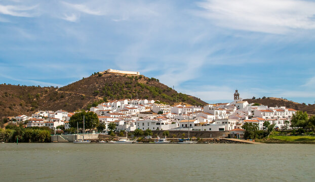 Sanlúcar de Guadiana a orillas del río Guadiana en la frontera con Portugal. A la izquierda su fortaleza de San Marcos restaurada con su encalado original y a la derecha el campanario de su iglesia.