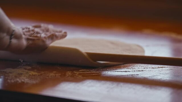 Close-up of Female Hands Flattening Dough Using Rolling Pin as Part of Preparation of a Traditional Balkan Dish Known as Borek
