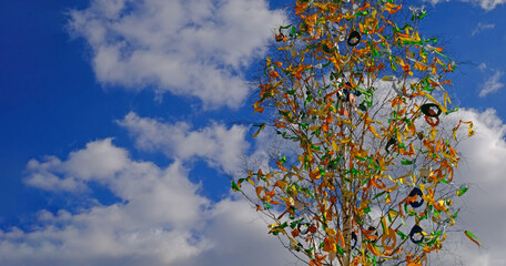 Beautiful colorful decor for Easter. Traditional Easter painted eggs and ribbons on a birch tree in Easter decor at the spring fair in Prague, Czech Republic. Selective focus.