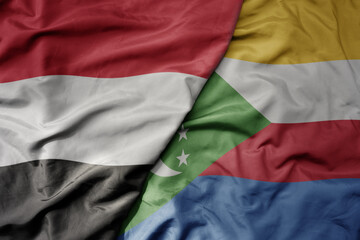 big waving national colorful flag of comoros and national flag of yemen .