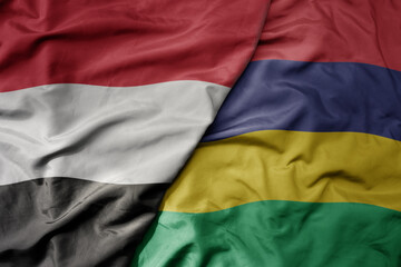 big waving national colorful flag of mauritius and national flag of yemen .