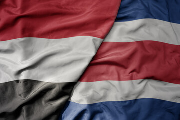 big waving national colorful flag of costa rica and national flag of yemen .