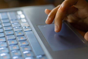 Close up image of hands typing on laptop computer keyboard and surfing the internet at home....