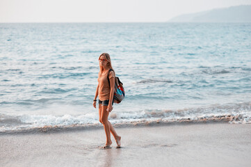 Vacation on the seashore.Young woman in shorts on the tropical sand beach.