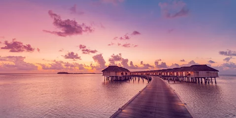 Photo sur Plexiglas Bora Bora, Polynésie française Amazing sunset panorama at Maldives. Luxury resort villas seascape with soft led lights under colorful sky. Beautiful twilight sky and dreamy clouds. Majestic beach background for vacation holiday