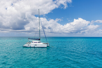 White sailing boat traveling in Maldives blue sea water on a bright sunny summer day in the middle of nowhere. Tropical sea and sailing boat. No sails up in calm sea waves. Freedom adventure tourism