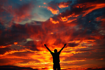 Silhouette of a Man Celebrating at Sunset