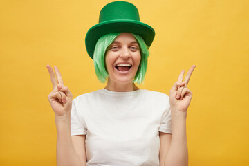 Traditional Irish celebration. Smiling happy delighted woman with green hair wearing leprechaun hat...
