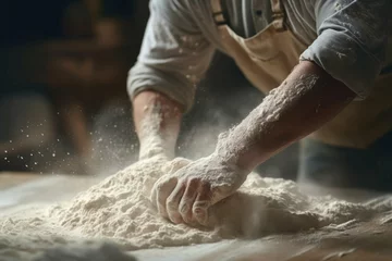 Selbstklebende Fototapeten Baker kneading dough with flour dusting the air. © Michael Böhm