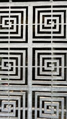 Black and white maze. Iron metal grating. Fragment of a lattice door. Light background. White maze...