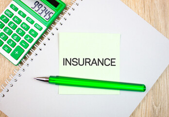 INSURANCE text,acronym note with calculator. Insurance financial concept.