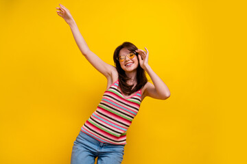 Photo of satisfied adorable girl with stylish hairdo wear striped tank touch glasses dancing in...