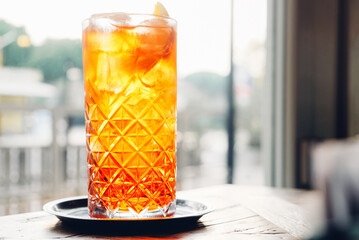 Glass of refreshing Aperol Spritz, popular Italian cocktail and summer aperitif drink prepared with...