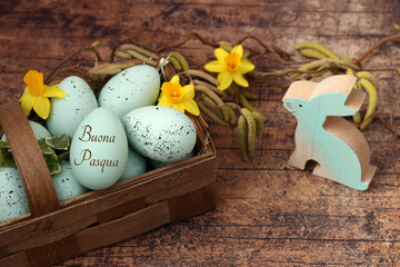 Cesto pasquale decorativo con narcisi e un uovo di Pasqua con la scritta “Buona Pasqua”.