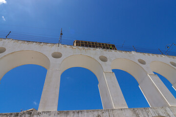 Obraz premium Rio de Janeiro, RJ, Brazil, 03/11/2024 - Carioca Aqueduct, also known as Arcos da Lapa, was erected in the 18th century in downtown Rio. The Santa Teresa cable car passes the top of the aqueduct