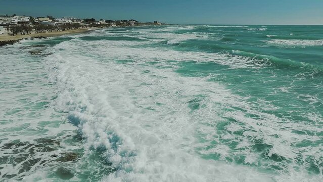 Inseguimento di un'onda nel mare con schiuma, ripresa con drone