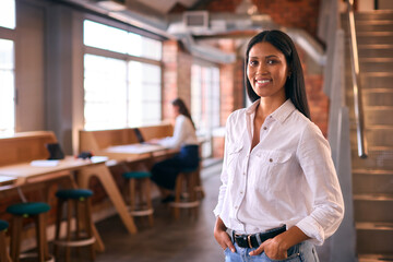 Portrait Of Smiling Young Businesswoman Working In Modern Open Plan Office  - 757183330