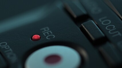 Red recording light glows on Audio Device. Close-up, shallow dof.