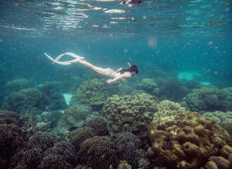 Fototapeta na wymiar A tourist woman snorkeling near Lipe island, a small island in Thailand in Satun, Thailand