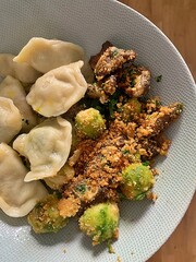 a plate with dumplings, Brussels sprouts with breadcrumbs, a plate with dinner, a warm dish