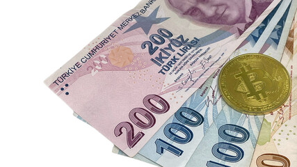 Turkish Lira notes with a golden Bitcoin coin on top, symbolizing the interface between traditional currency and digital cryptocurrency within the financial landscape.