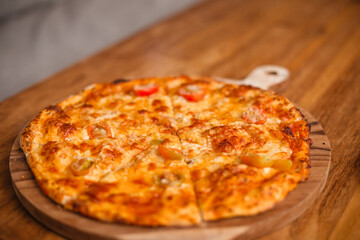 Pizza Margherita on a wooden table with space for text. A stylish concept for advertising an Italian cafe and pizza.