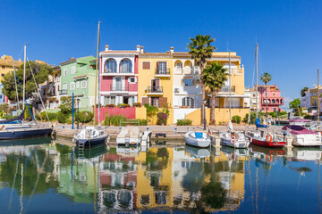 Colorful houses reflected in the water of Port Saplaya in Valencia, Spain