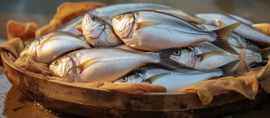 A wooden bowl filled with fish, a staple food ingredient, sits on a table ready to be used in a delicious fish dish recipe