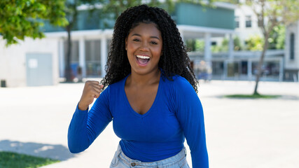 Laughing and cheering african american young adult woman in the city