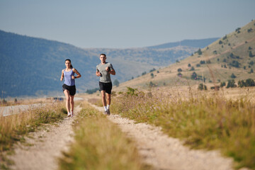 Energized by the beauty of nature, a couple powers through their morning run, their bodies and spirits invigorated.