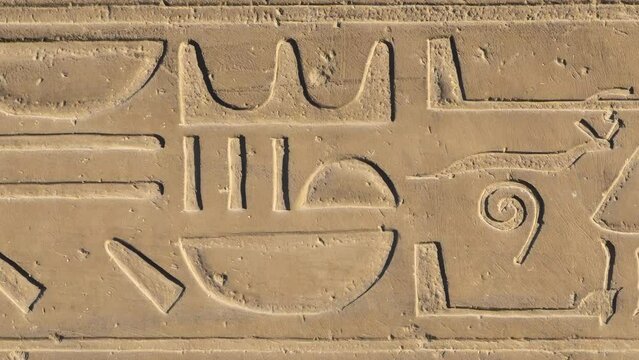 Egyptian hieroglyphs close-up in Luxor Temple, ancient Thebes, Egypt. Luxor Temple is a large Ancient Egyptian temple complex located on the east bank of the Nile River and was constructed 1400 BCE.
