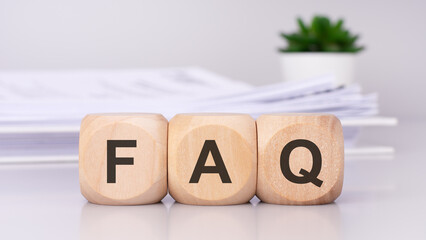 FAQ text on wooden cubes on the gray background. Tax business concept