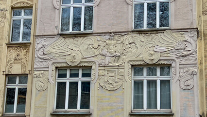 Bas-reliefs on the walls of the house. An ancient hero tames fabulous sea creatures. Patterns....